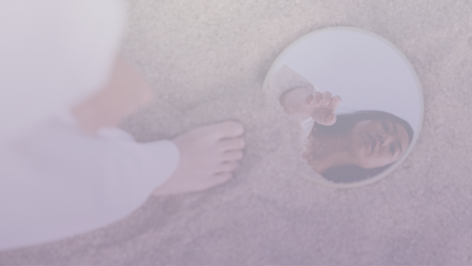 Mulher observando o próprio reflexo em um espelho, em referência ao autoconhecimento na psicoterapia